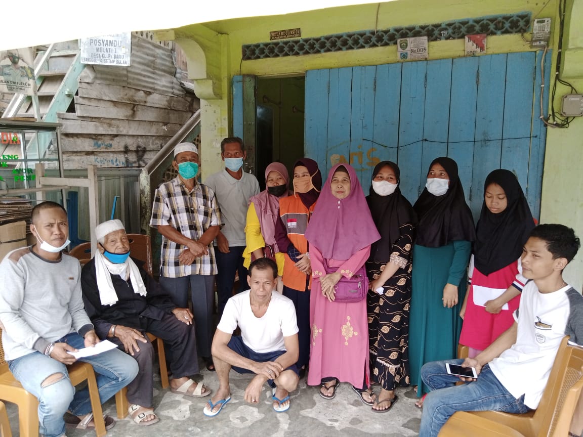 Mahrub (paling kiri), Jamiin (duduk berpeci) dan keluarga korban kebakaran lainnya saat berfoto bersama relawan Rumah Zakat usai serah terima bantuan.